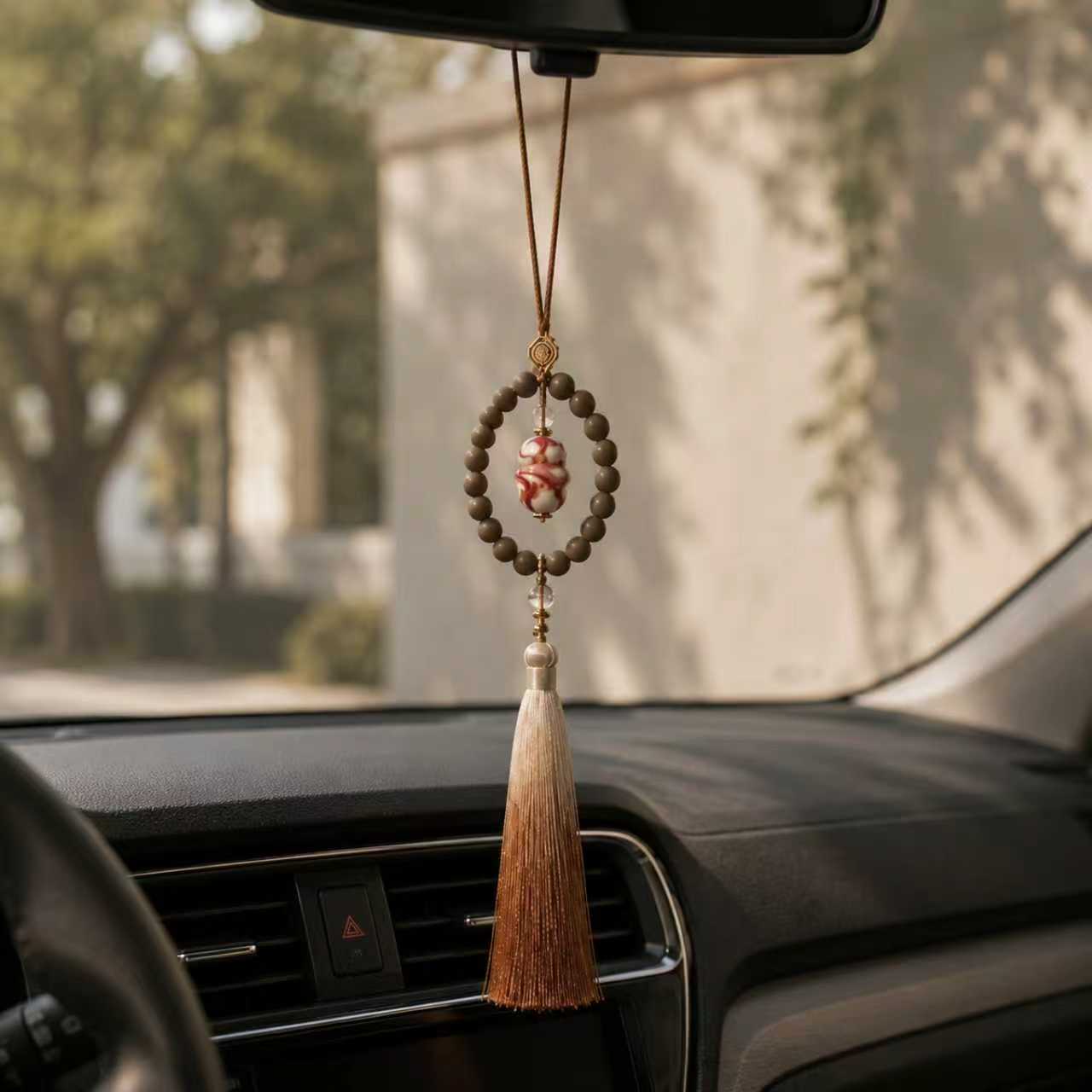 Botanical car scent charm hanging from a rearview mirror