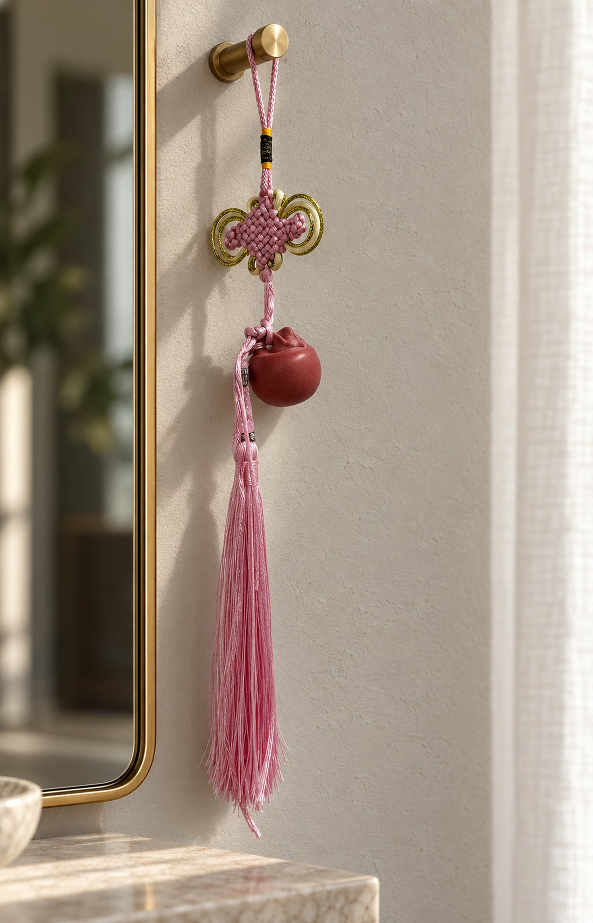 Pink charm hanging beside an entryway mirror